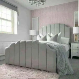 Front view of a grey velvet Wingback Arizona bed with a tall panelled headboard and silver chrome feet.